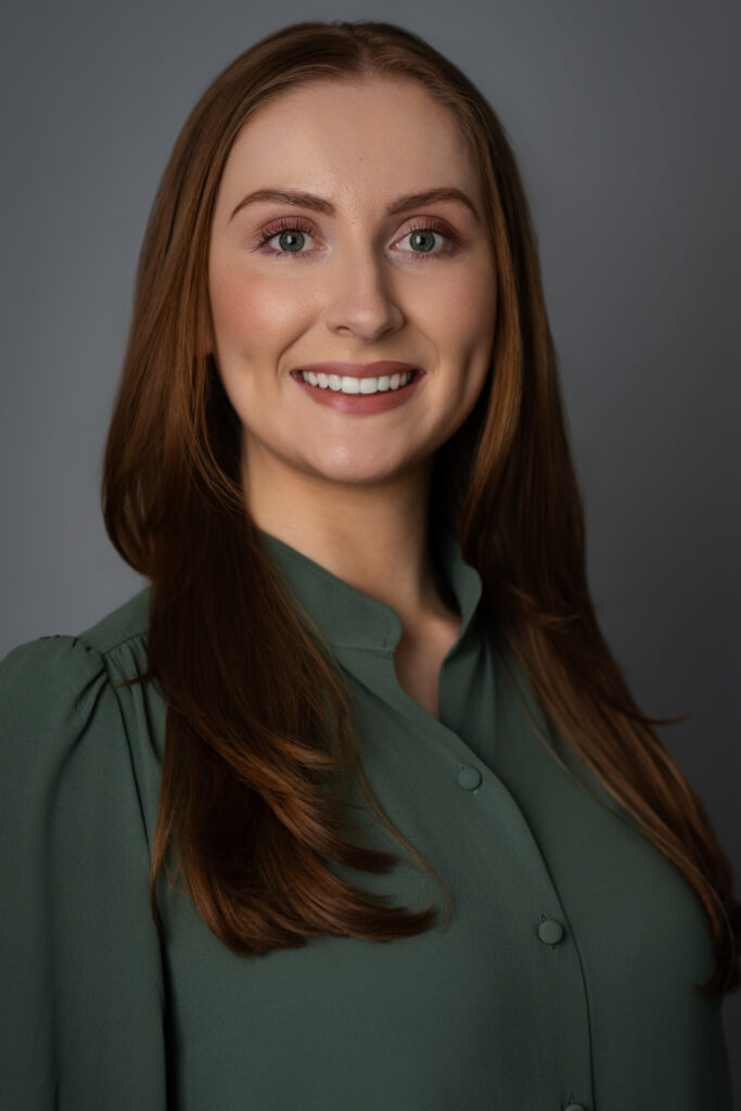 Caroline displaying warm confidence in a studio headshot, perfect for speaking engagements and press features.