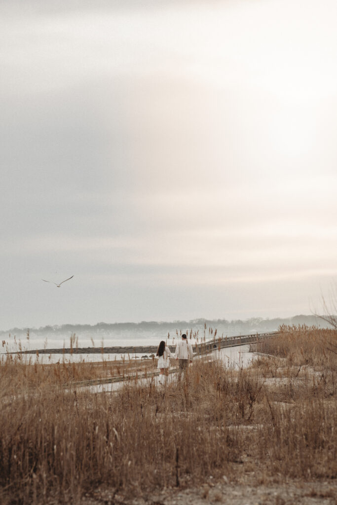 A wide landscape shot of the Silver Sands boardwalk and beach under a soft sunset sky, capturing the "coastal beauty" of the location.